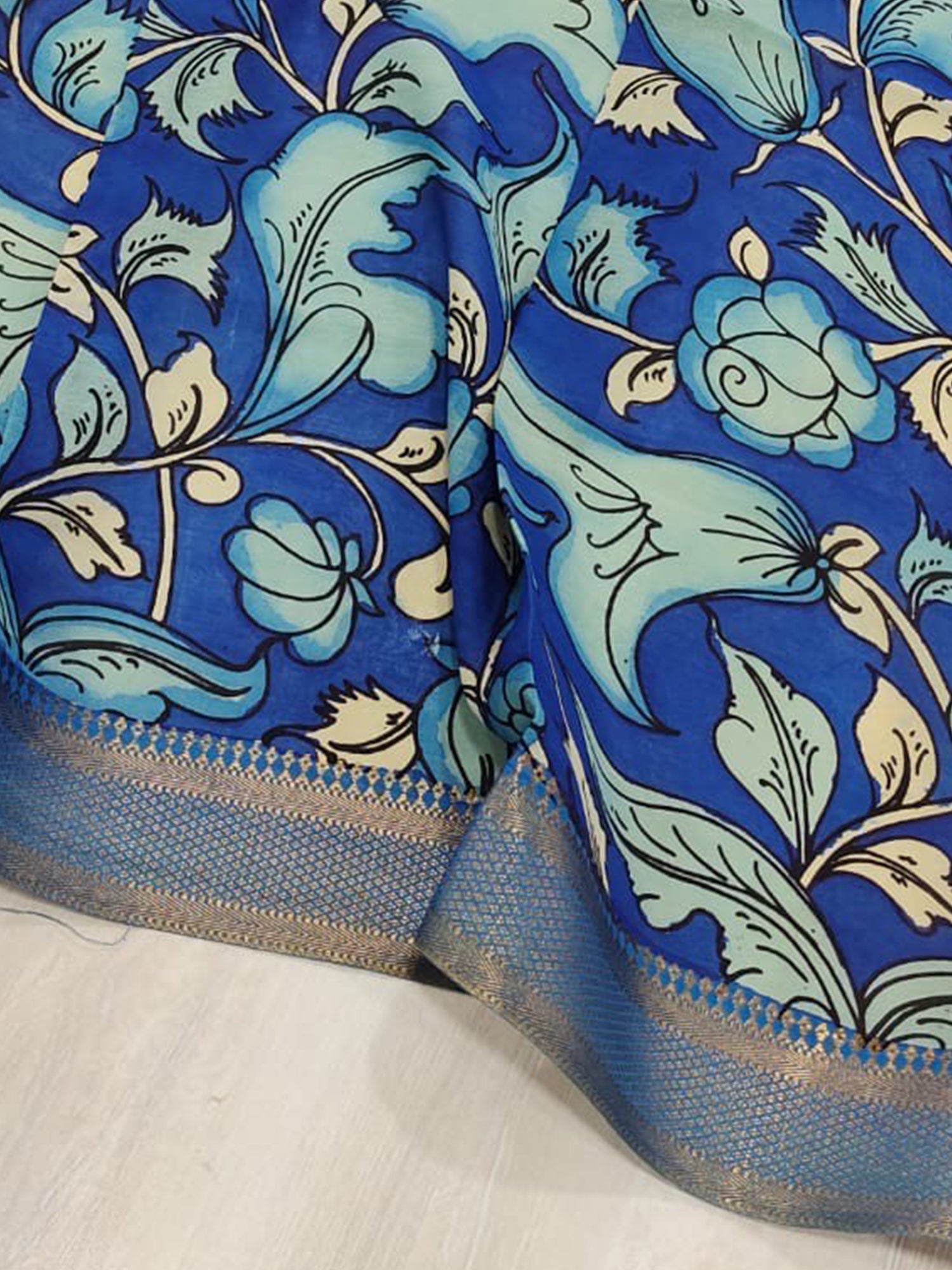 A blue hand-painted Kalamkari dupatta with floral motifs from Mrida.