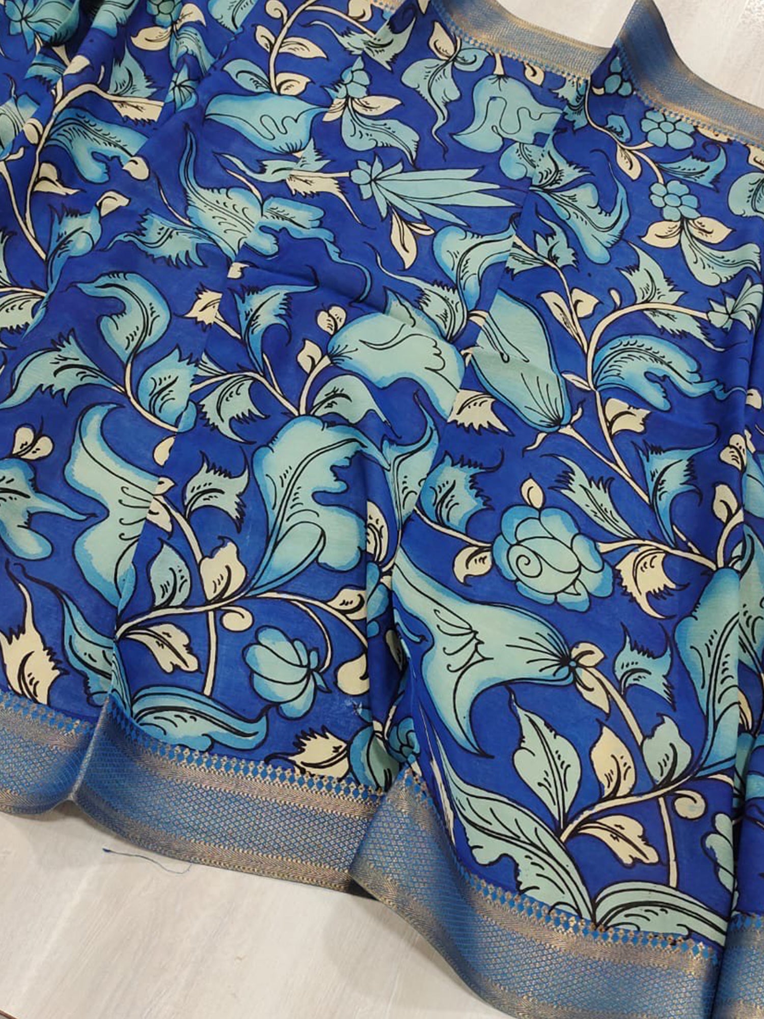 A blue hand-painted Kalamkari dupatta with floral motifs from Mrida.