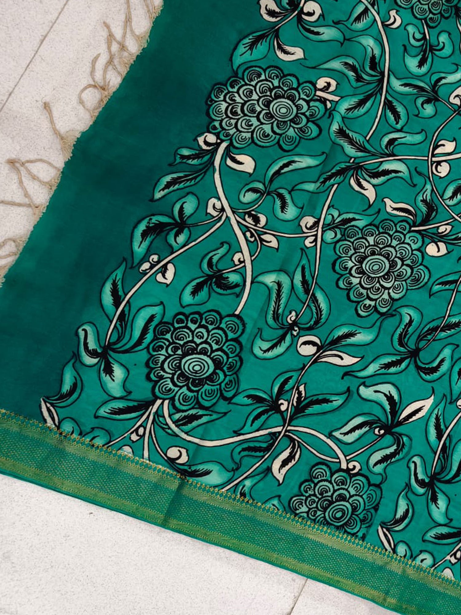A green hand-painted Kalamkari dupatta with floral patterns from Mrida.