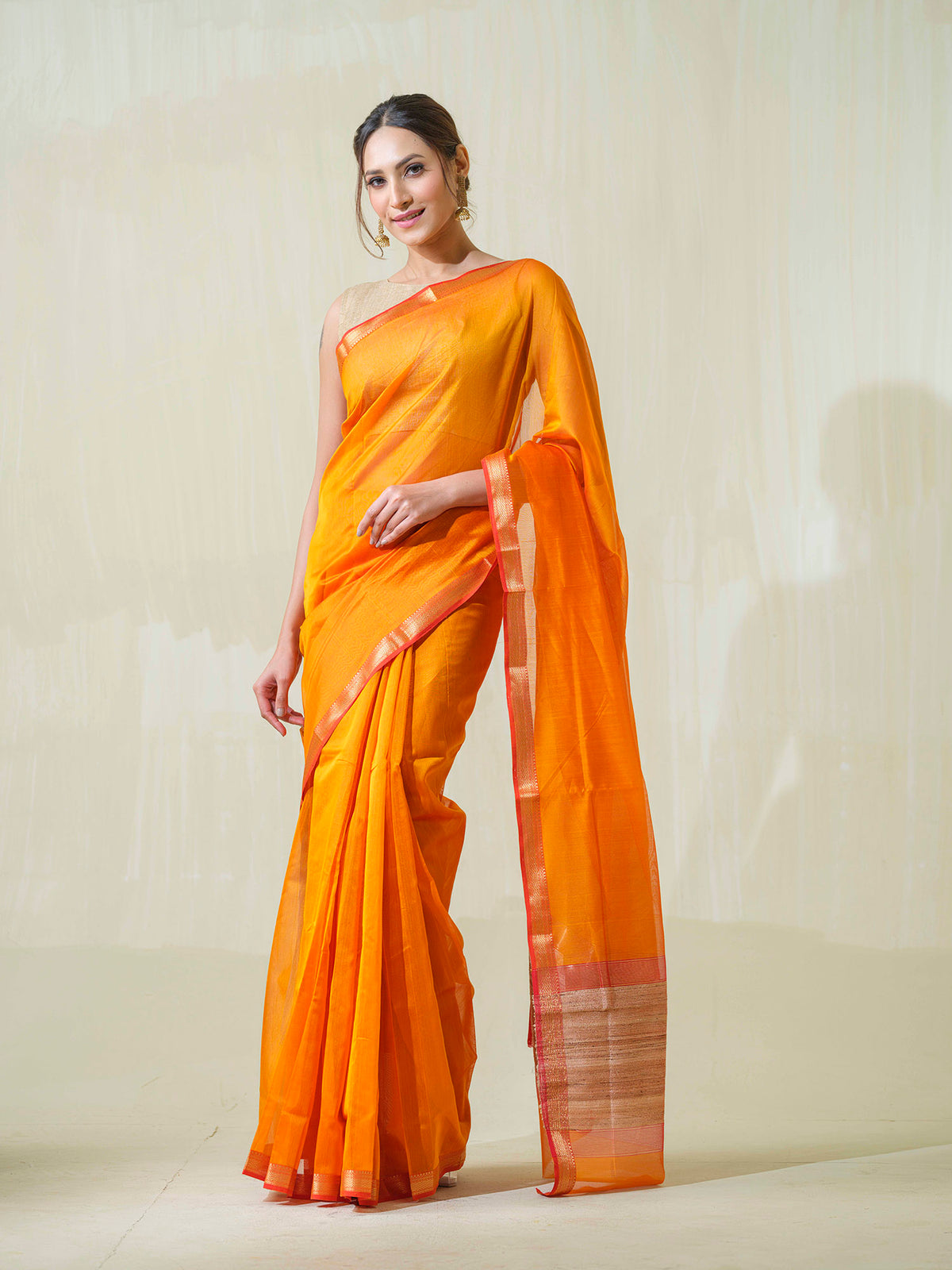 Saffron Maheshwari cotton silk saree with jute work pallu.