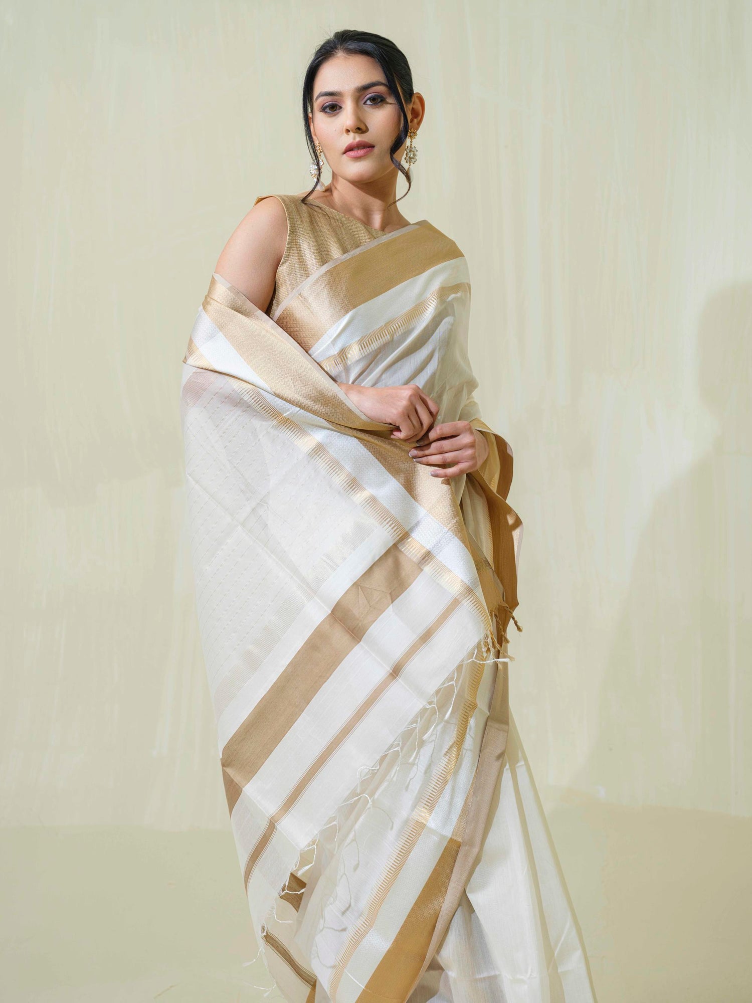 An Indian women wearing Off-White Maheshwari Cotton-Silk Saree with Resham, paired with light colored blouse. From the Saadgi Collection by Mrida.